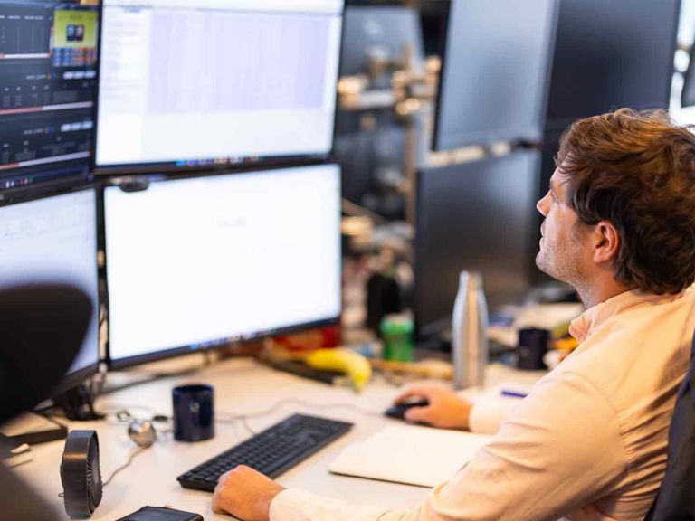 SF Person At A Desk Reviewing Multiple Monitors 494