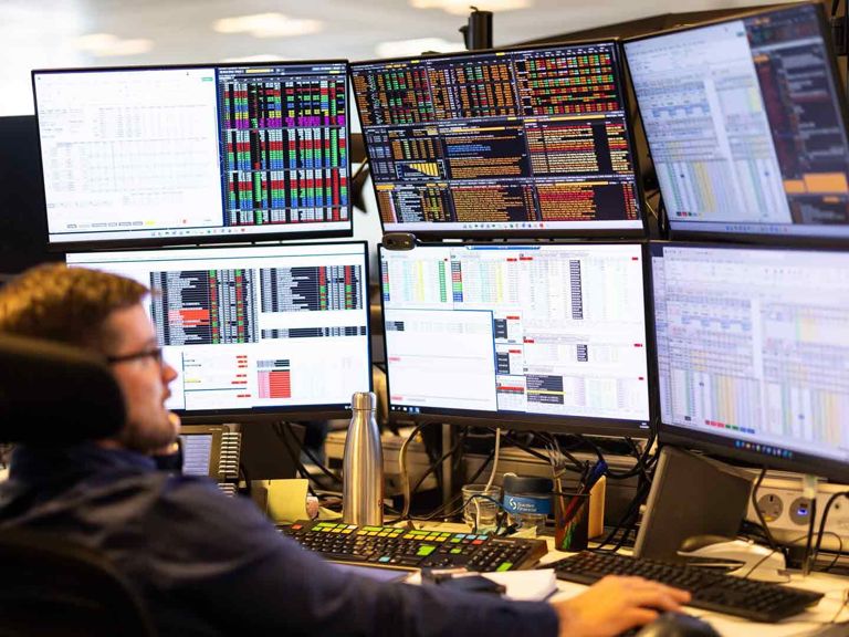 SF Person Analysing Multiple Monitors Displaying Financial Data 470