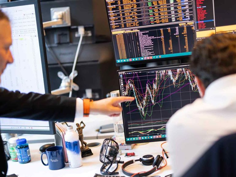 SF Two Individuals In An Office Setting Analyse Complex Financial Charts On Multiple Monitors 19